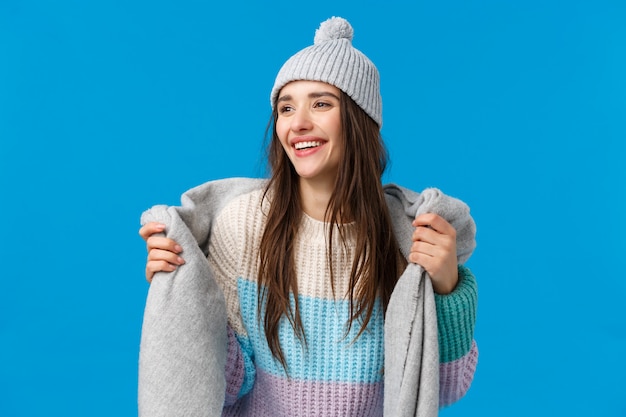 Attractive and carefree, dreamy pretty woman with long dark hair, wearing winter hat