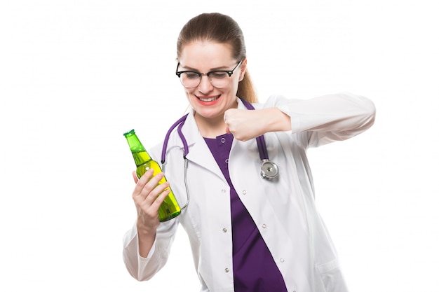 Attractive caucasian brunette female doctor standing in office with bottle of beer in her hands showing prevention sign