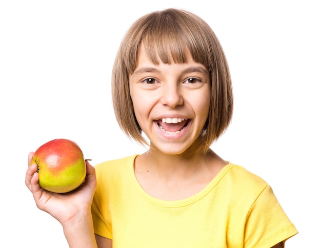 白い背景にリンゴを孤立させた魅力的な白人の女の子 笑顔でカメラを見ている学校の女の子 新鮮な果物を持つ幸せな子供 感情的な肖像画クローズアップ