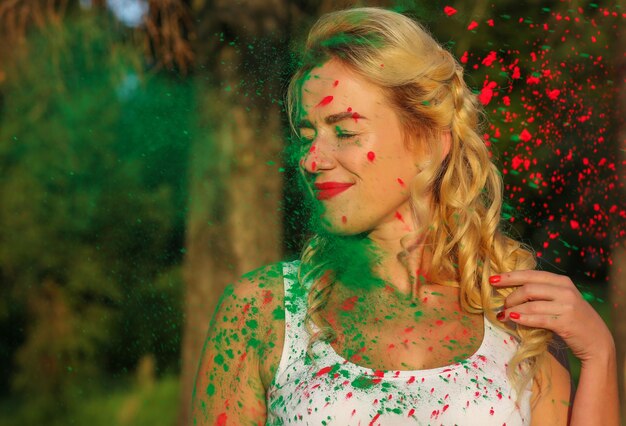 Attractive caucasian model with long wavy hair posing with color splash of a dry Holi paint