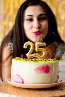 Attraente donna caucasica in abito da festa nero pronto a mangiare la torta di compleanno