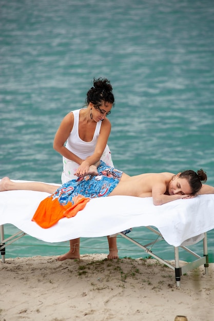 An attractive caucasian woman lying down on a massage bed at a spa