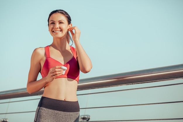 Attractive caucasian woman using earphones while training outdoors