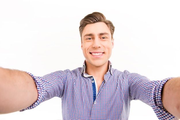 Attractive cheerful happy young man making selfie