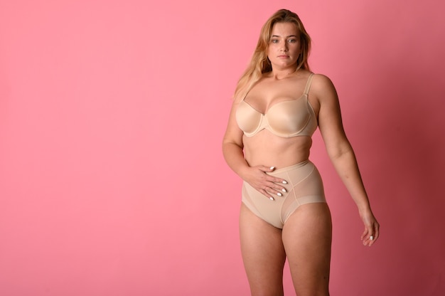 Attractive chubby girl in underwear on pink