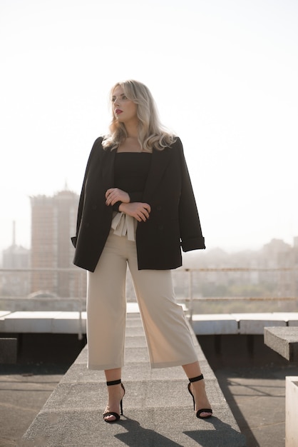 Attractive city woman enjoys sun over the rooftops of a city.