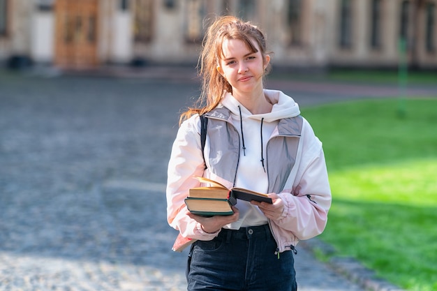 Attractive confident young woman with books