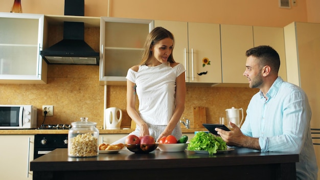 Attractive couple chatting in the kitchen early morning