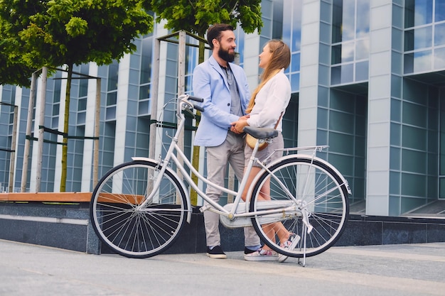 街で自転車に乗った後のデートで魅力的なカップル。