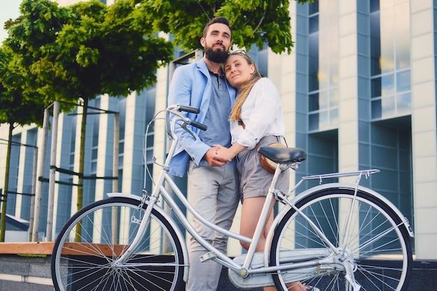 街で自転車に乗った後のデートで魅力的なカップル。