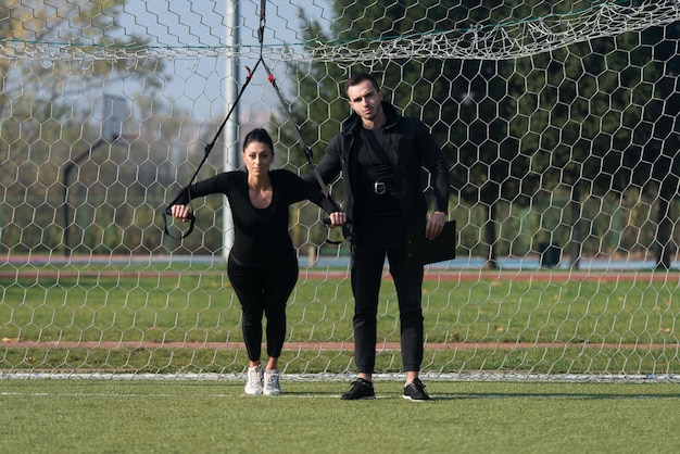 Attractive Couple Doing Crossfit With Trx Fitness Straps in City Park Area  Training and Exercising for Endurance  Healthy Lifestyle Concept Outdoor