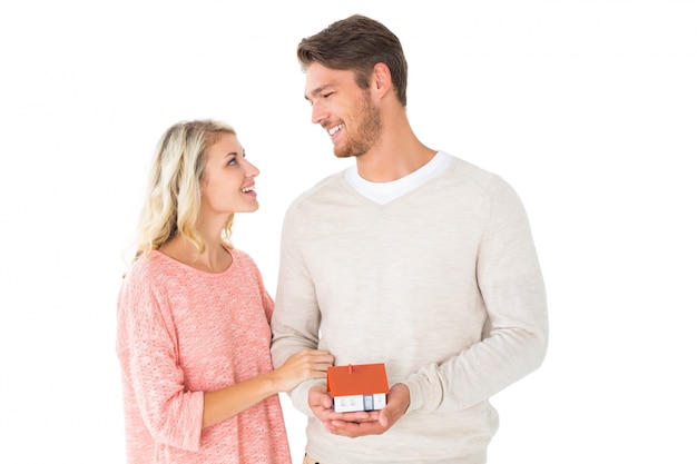 Attractive couple holding miniature house model