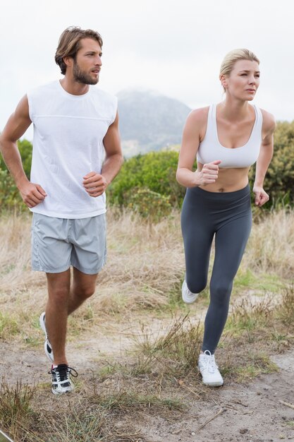 Photo attractive couple jogging on mountain trail