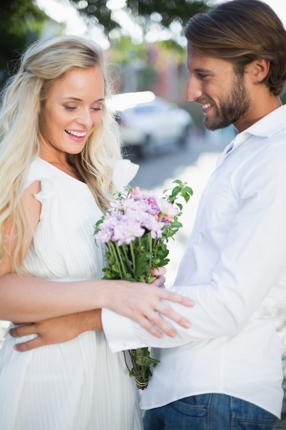 Attractive couple with bunch of flowers