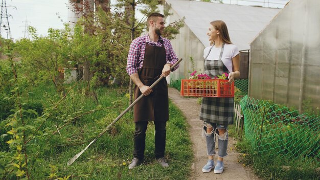 Attractive couple work near greenhouse