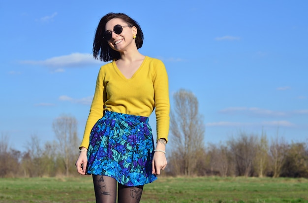 Attractive and cute Brunette girl in a yellow sweater walks thro