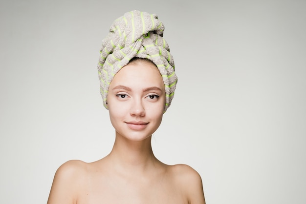 Привлекательная милая девушка с полотенцем на голове хочет быть красивой