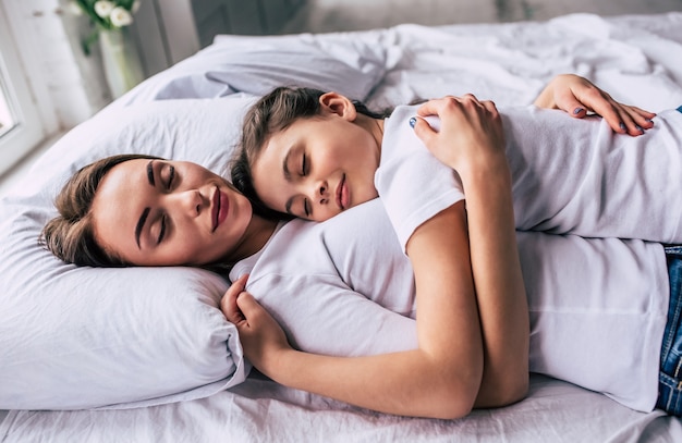 The attractive daughter and a mother sleeping on the bed