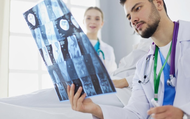 Attractive doctor examining an x-ray and smiling at the camera