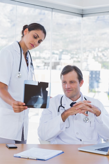 Attractive doctor showing a x ray to a colleague