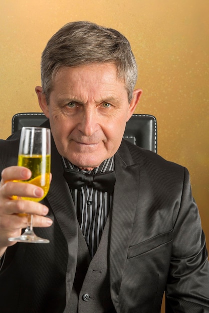 Photo attractive elderly man proposing a toast with glass