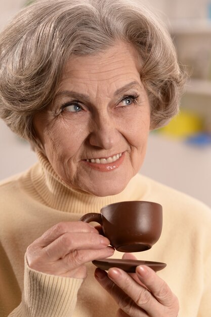 Attractive elderly woman with cup of coffee