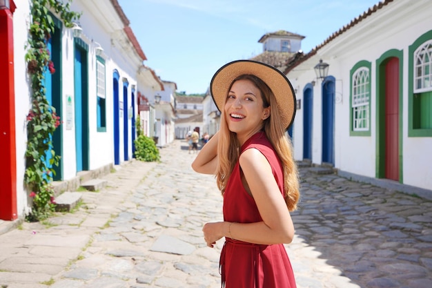 Attractive excited tourist woman turns around and looking behind Traveler girl visiting Paraty Rio de Janeiro Brazil