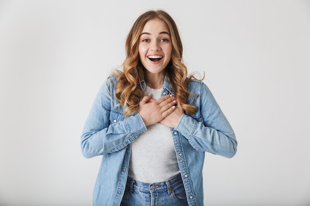 Attractive excited young girl wearing casual clothes standing isolated over white 