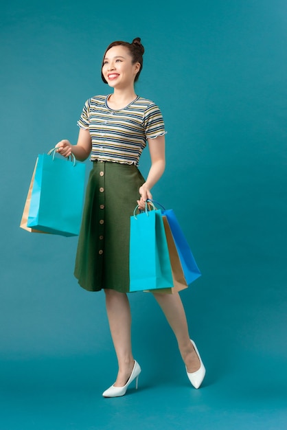 An attractive fashionable woman holding colorful paper shopping bags