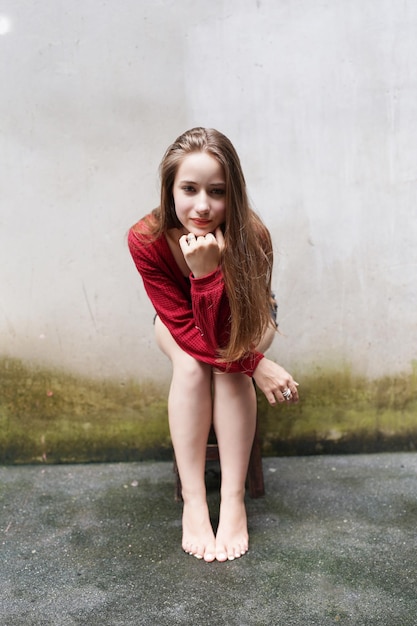 Photo attractive fashionable young woman posing in sexy clothes against wall