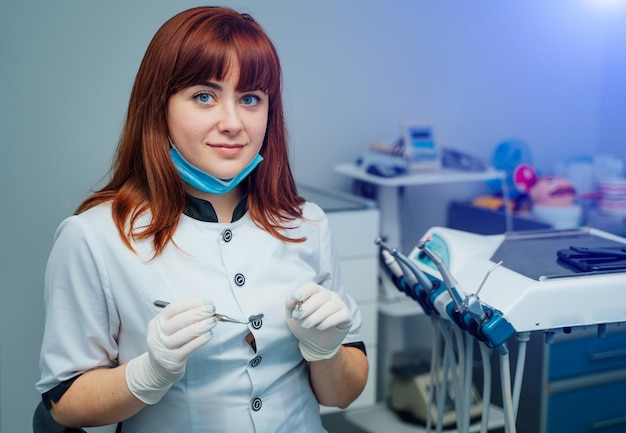 Foto dentista femminile attraente che posa in uno studio dentistico moderno concetto di stomatologia della salute della medicina