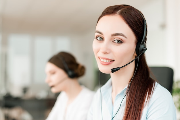 Attractive female dispatcher answering business calls in the modern company office