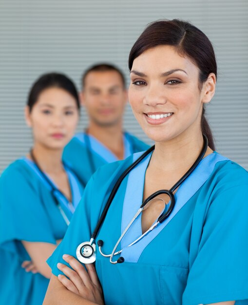 Attractive female doctor with his colleagues in the background