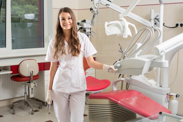 Attractive female doctor with microscope in the modern dentist office