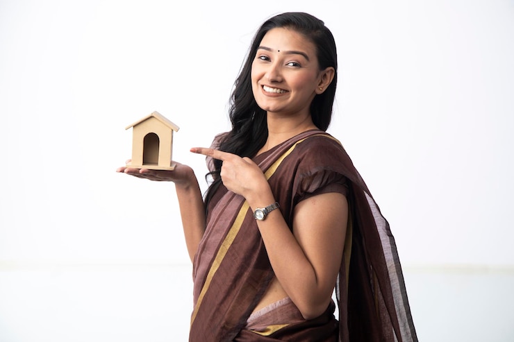 फोटो attractive female model posing with toy house in front of camera