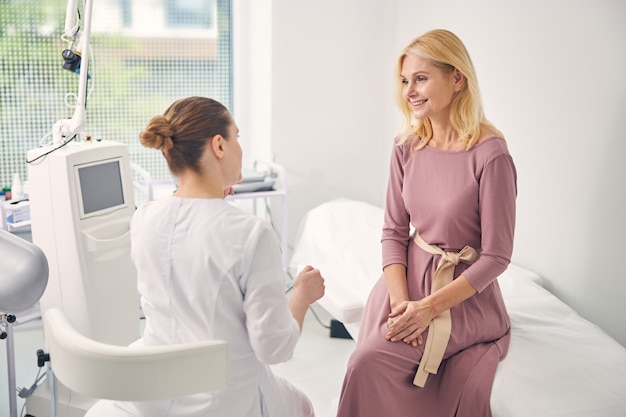 Attractive female person expressing positivity while being on medical consultation, feeling happiness at moment