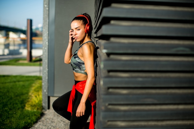 Attractive female  runner taking break after jogging outdoors