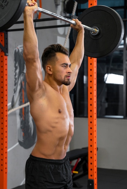 Photo attractive fit man working out indoors with weights