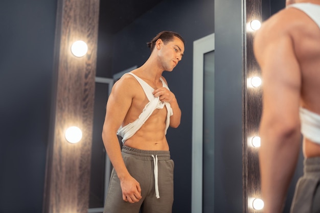 Attractive fit young man posing in front of a mirror