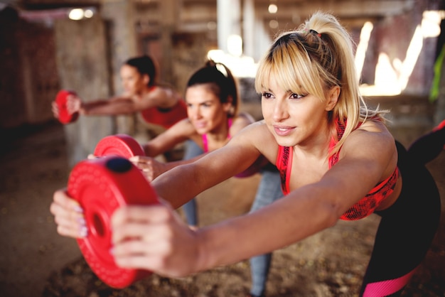 Attractive fitness people working out training legs doing squats.