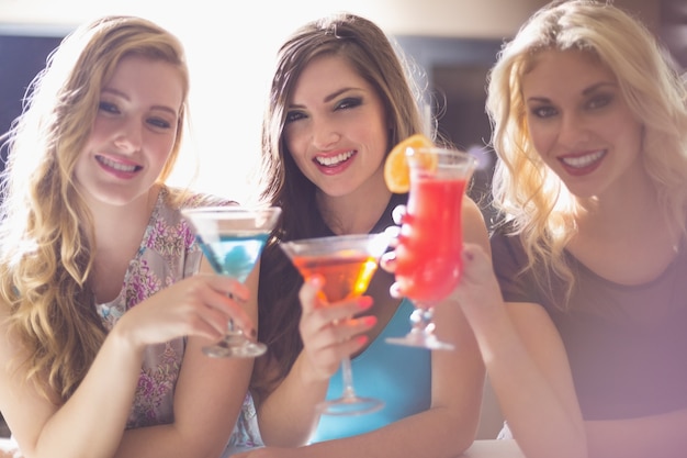 Attractive friends drinking cocktails together