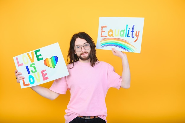 Attractive gay caucasian man holding a protest sign during a LGBT pride parade Equality