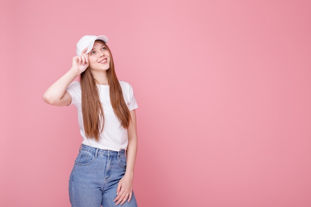 Attractive girl in a cap on a pink background