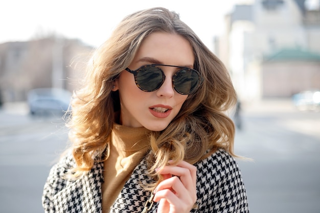 Attractive girl in a coat posing in the street