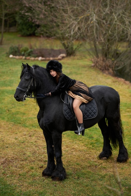 attractive girl in a dress riding a dark horse