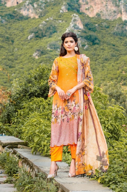 Attractive Girl Front Pose Standing Alone on Mountain Hill Wearing Yellow Desi Dress for Photoshoot