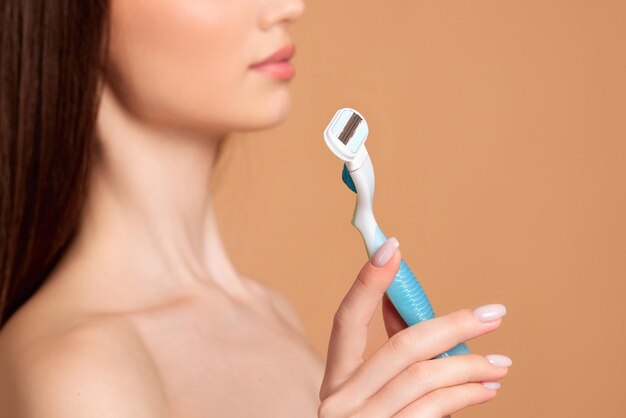 Attractive girl holding in hand razor shaver blade i