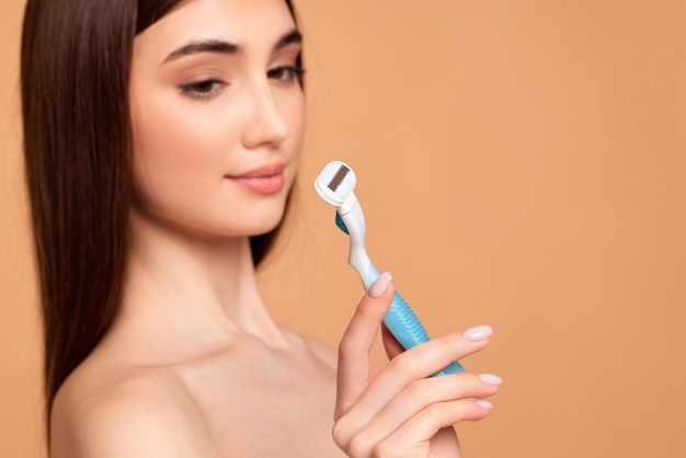 Attractive girl holding in hand razor shaver blade i