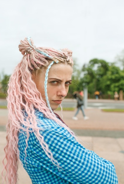 Фото Привлекательная девушка в наушниках с розовыми волосами и синей рубашкой