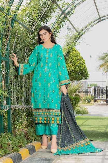 Attractive Girl Posing in Garden Wearing Traditional Dress for Fashion Shoot